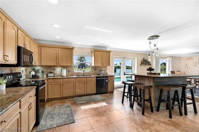 kitchen featuring pendant lighting, a kitchen breakfast bar, tasteful backsplash, black appliances, and french doors