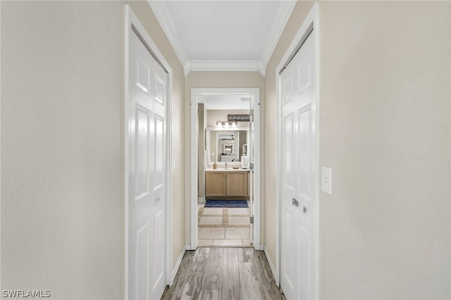 corridor with crown molding and light wood-type flooring