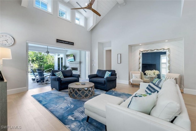 living room featuring a fireplace, wood finished floors, a wealth of natural light, and a ceiling fan