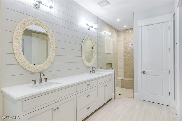 full bathroom featuring double vanity, visible vents, walk in shower, and a sink