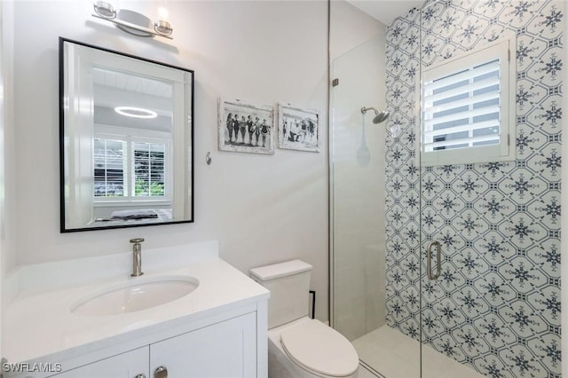 full bath featuring a stall shower, vanity, and toilet