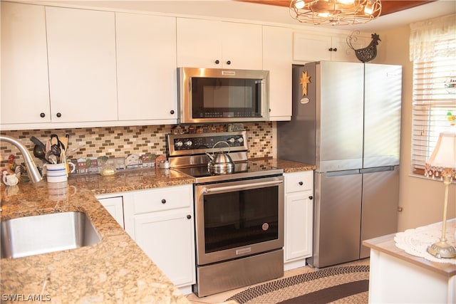 kitchen featuring white cabinetry, sink, stainless steel appliances, and stone countertops