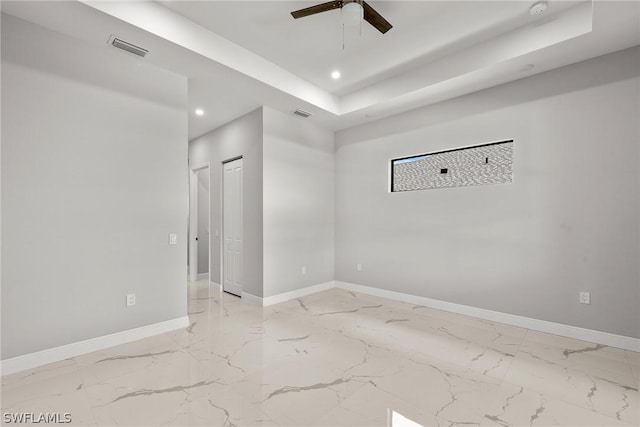 spare room featuring ceiling fan and a tray ceiling