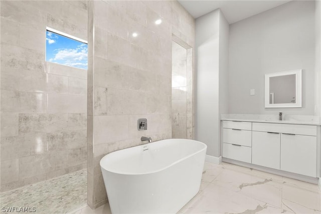 bathroom with tile walls, a bathtub, and vanity