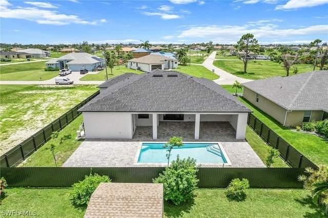 back of house featuring a fenced in pool, a yard, and a patio