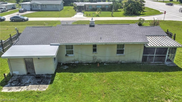 back of house featuring a sunroom and a lawn