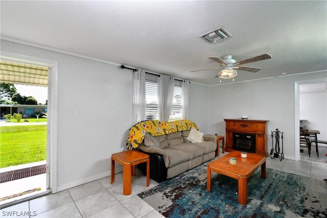 living room with a wealth of natural light, light tile patterned floors, and ceiling fan