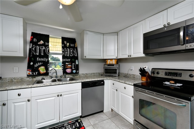 kitchen featuring white cabinets, stainless steel appliances, sink, light tile patterned floors, and ceiling fan