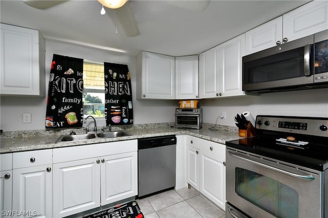 1235 Joerin Ave, North Fort Myers, FL 33903 - kitchen featuring white cabinets, ceiling fan, stainless steel appliances, a sink, and light tile patterned floors