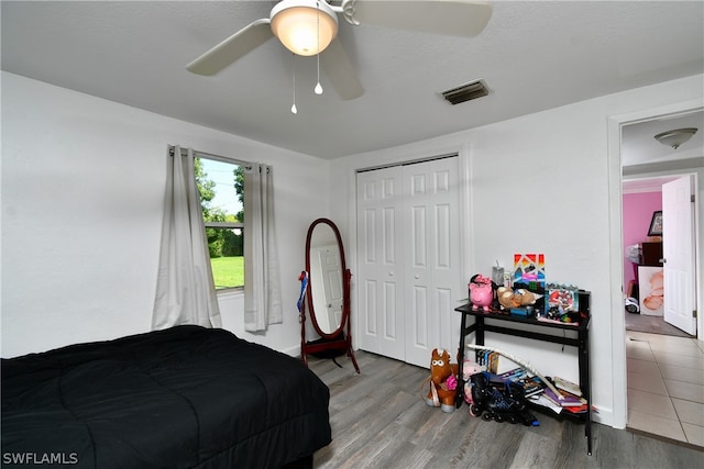 bedroom with ceiling fan, hardwood / wood-style flooring, and a closet