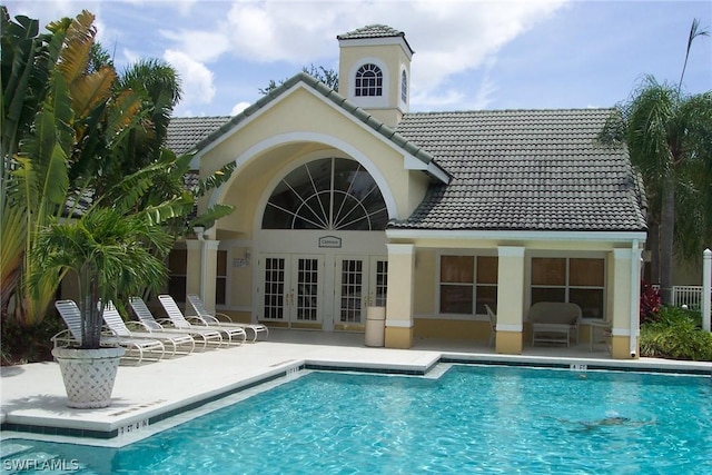 back of house featuring a community pool, a patio, and french doors