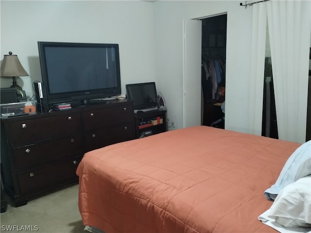 bedroom with light colored carpet and a closet