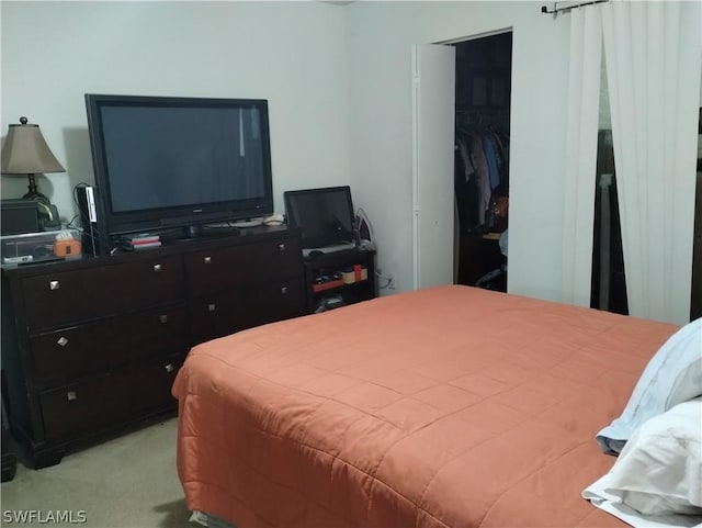 bedroom featuring light carpet and a closet