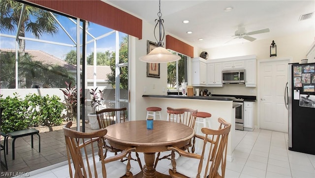 tiled dining room featuring ceiling fan