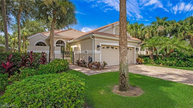 mediterranean / spanish-style home with a garage and a front lawn