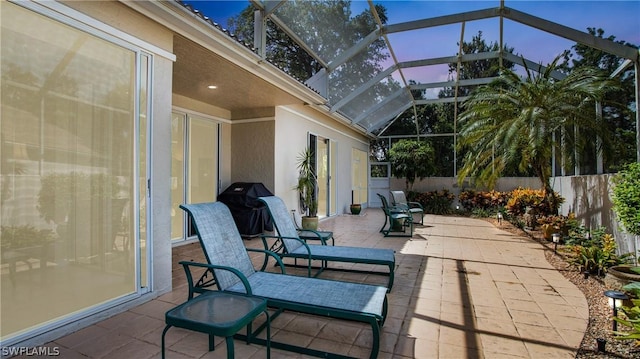 patio terrace at dusk featuring grilling area and a lanai