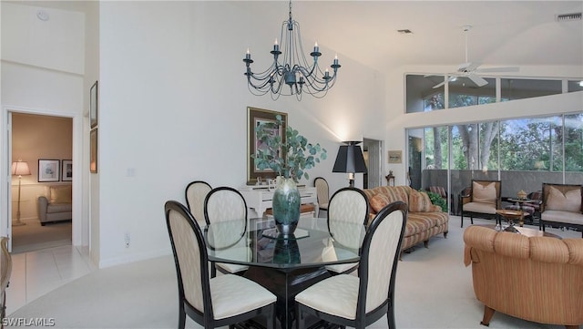 tiled dining area with ceiling fan with notable chandelier and high vaulted ceiling