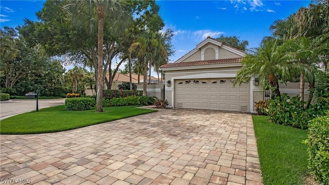 view of front of home with a garage and a front lawn