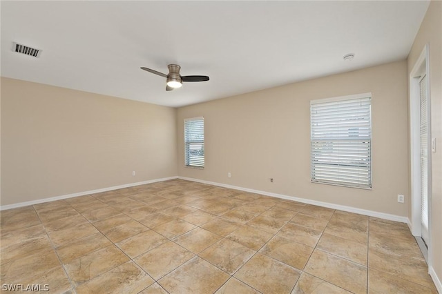 spare room with ceiling fan and light tile patterned flooring