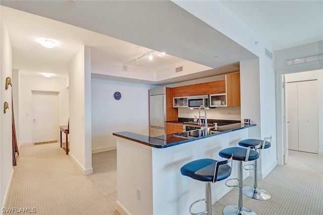 3000 Oasis Grand Blvd Unit 1704, Fort Myers, FL 33916 - kitchen featuring brown cabinets, built in fridge, dark countertops, a breakfast bar, and a peninsula