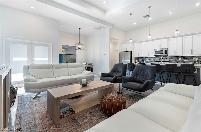 living room featuring french doors and a chandelier