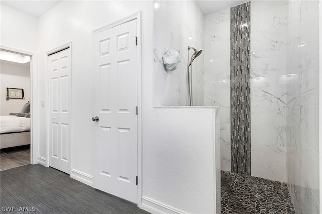 bathroom featuring hardwood / wood-style flooring and a tile shower