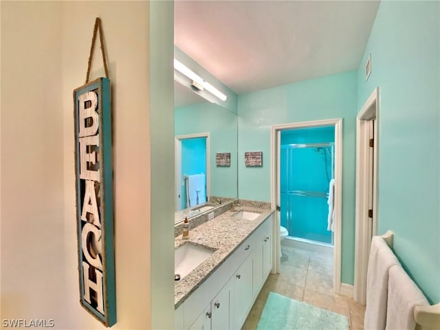 bathroom featuring tile patterned floors, vanity, toilet, and a shower with shower door