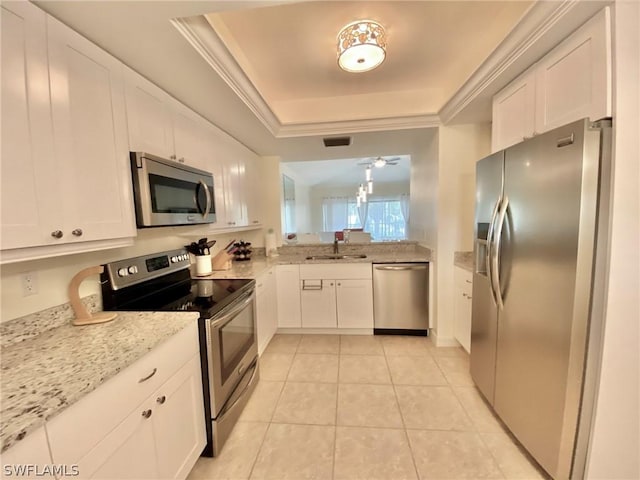 kitchen with white cabinetry, appliances with stainless steel finishes, a raised ceiling, and sink