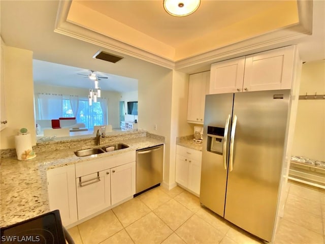 kitchen with sink, light stone counters, white cabinetry, light tile patterned floors, and stainless steel appliances