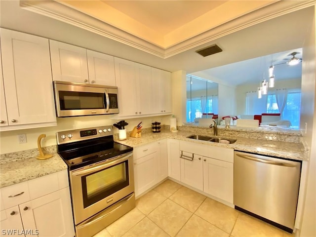 kitchen featuring a raised ceiling, white cabinetry, appliances with stainless steel finishes, and sink