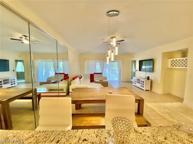 interior space with a wealth of natural light, ceiling fan, and vaulted ceiling