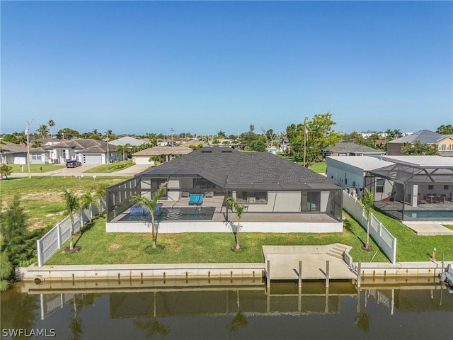 rear view of house with a water view, a yard, a lanai, and a fenced in pool