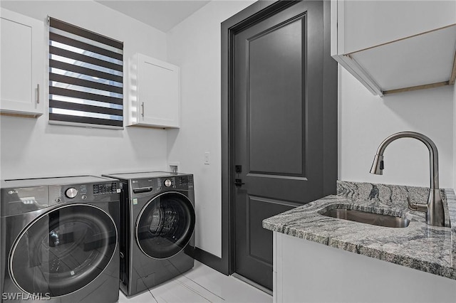 washroom featuring cabinets, light tile patterned flooring, separate washer and dryer, and sink