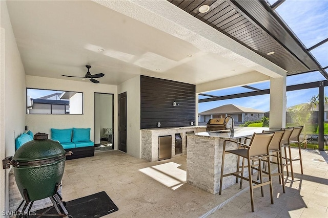 view of patio with outdoor lounge area, a wet bar, ceiling fan, and an outdoor kitchen