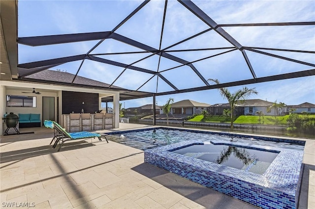 view of pool with a bar, an in ground hot tub, a lanai, ceiling fan, and a patio area