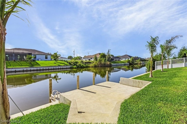 dock area with a water view and a yard