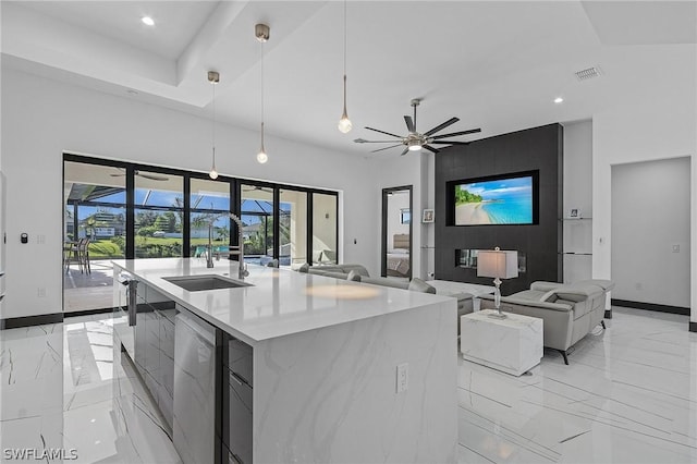 kitchen with decorative light fixtures, dishwasher, sink, ceiling fan, and a center island with sink