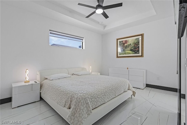 bedroom featuring a raised ceiling and ceiling fan