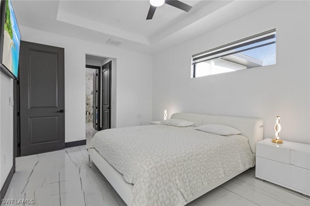 bedroom with ceiling fan and a raised ceiling