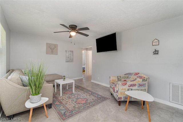 living room with ceiling fan and a textured ceiling