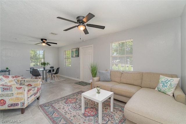 tiled living room featuring ceiling fan