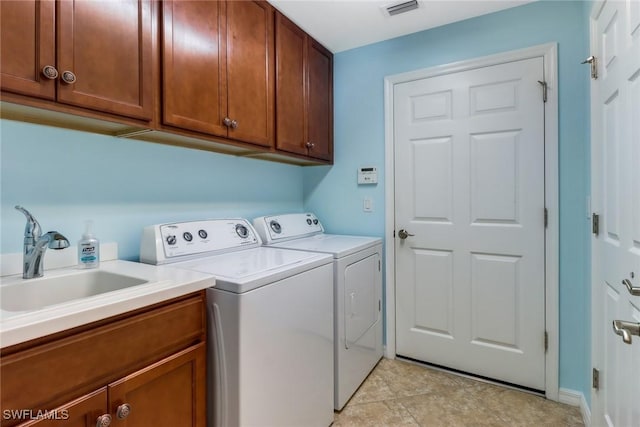 laundry room with washer and clothes dryer, cabinets, and sink