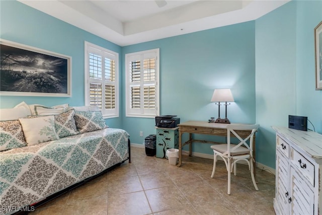 tiled bedroom featuring a tray ceiling and ceiling fan