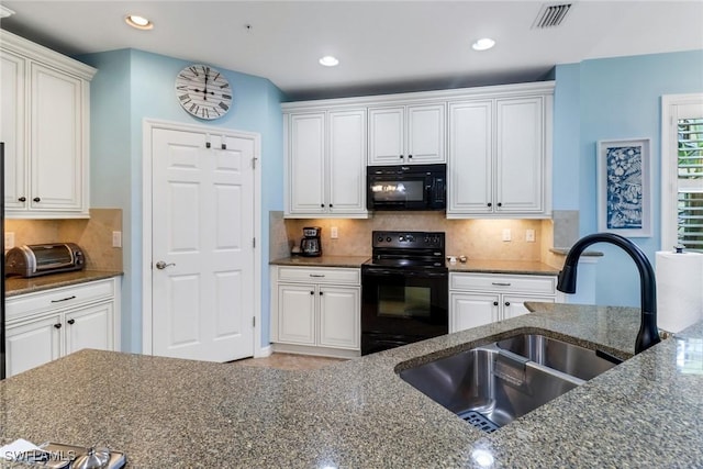 kitchen featuring black appliances, white cabinetry, and sink