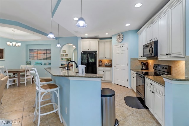 kitchen with backsplash, dark stone countertops, pendant lighting, and black appliances