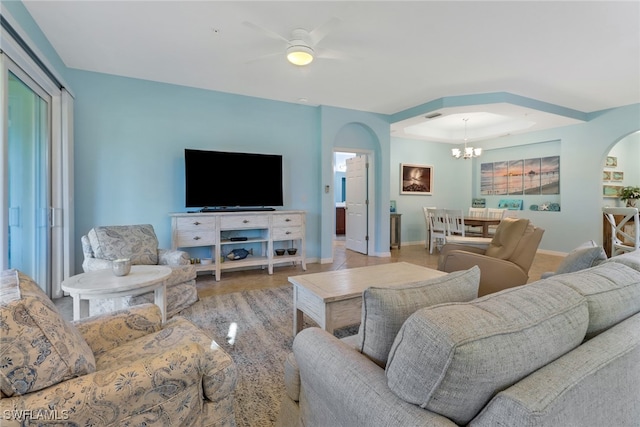 living room with ceiling fan with notable chandelier