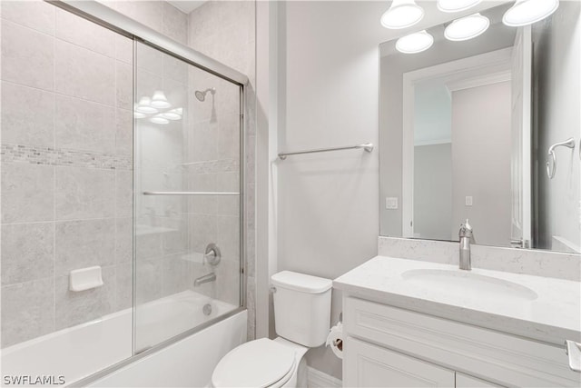 full bathroom with toilet, vanity, and bath / shower combo with glass door