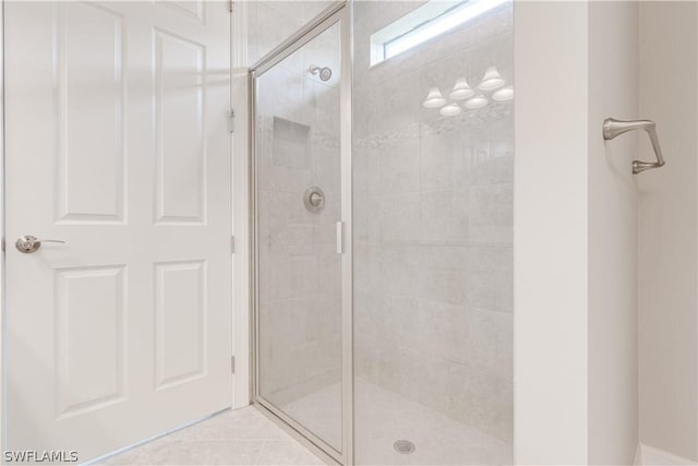 bathroom with tile patterned flooring and a shower with shower door