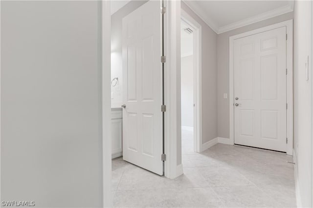 corridor with light tile patterned floors and crown molding