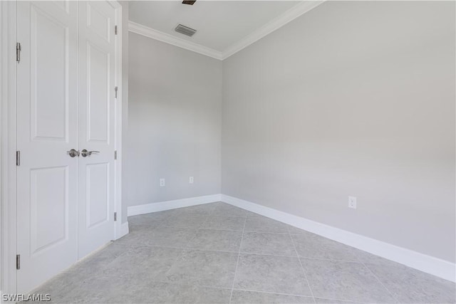 empty room featuring ornamental molding and light tile patterned floors